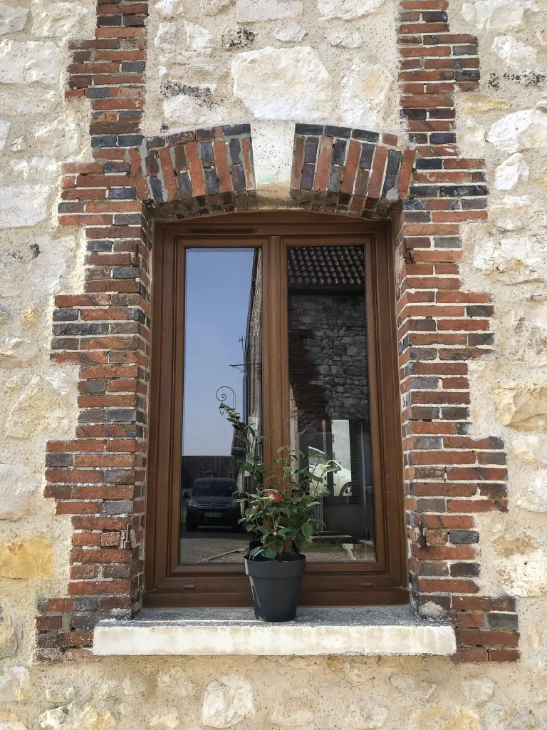 Fenêtre ton chêne dans une façade en brique et pierre à Reims